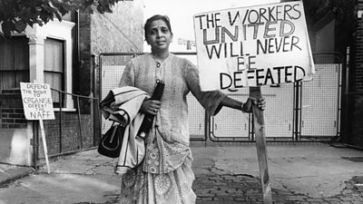 Female south asian striker holding placard