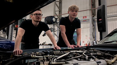 Two apprentices working on a Jaguar