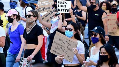 Woman holds injustice placard at a BLM rally