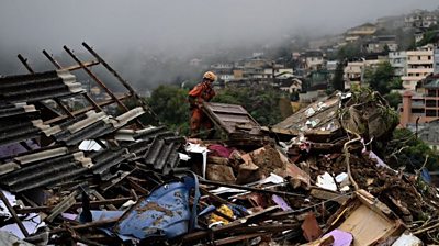 A rescuer searching destroyed houses in Brazil.