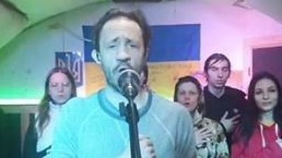 Man singing in front of Ukraine flag