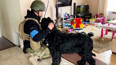 Ukrainian Soldier stroking a black dog