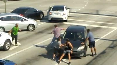 Passersby try to stop a moving car