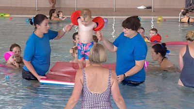 Children in swimming pool with teachers