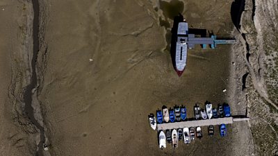 Boats are seen on the dried bed of the drought-affected Doubs River on the border with France in Les Brenets, Switzerland,