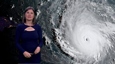 Helen Willetts stand in front of a satellite map