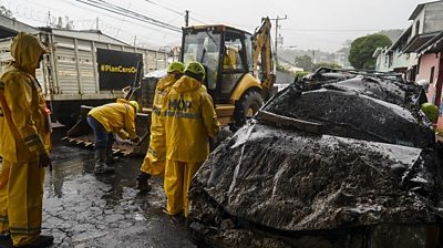 First responders extract a car damaged by a mudslide in El Salvador