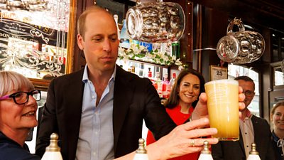 Prince William holding a pint of beer in his hand