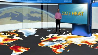 Ben Rich standing on a map of the globe showing temperature anomalies