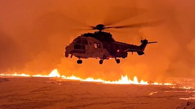 Helicopter flying over volcanic eruption