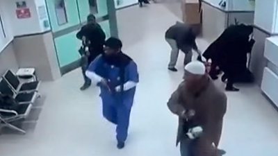 Three armed men walking through hospital disguised