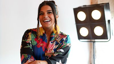 Sabrina Sandhu smiling to camera with studio lights in the background