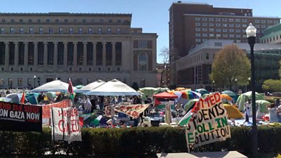Tents are pitched and protest signs displayed in front of Columbia University