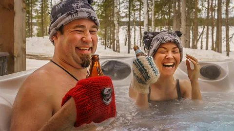 Couple in a hot tub enjoying a drink, Lapland, Finland