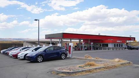 Tesla charging station beside a petrol station, US