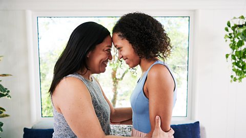 Mum shows her daughter that she loves her with a smile and a forehead to forehead hug