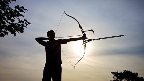 A silhouetted person with a bow and arrow