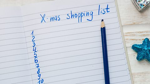 A piece of lined paper with 'X-mas shopping list' written at the top and then numbers 1-10 written down the side