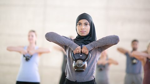 Person lifting weights in an exercise class