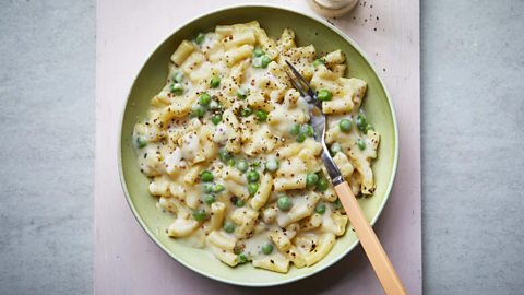 Pasta bowl of creamy mac and cheese with peas