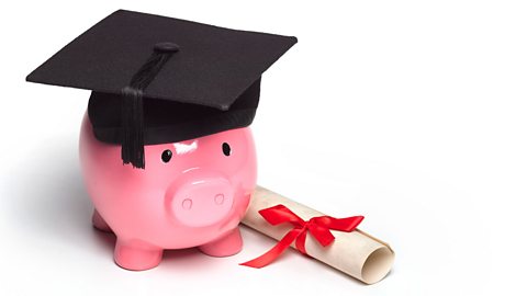 Graduate piggy bank wearing mortar board with diploma.