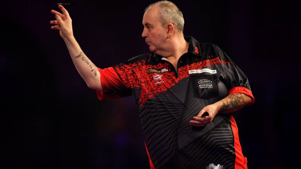 Phil Taylor throws a dart on the oche