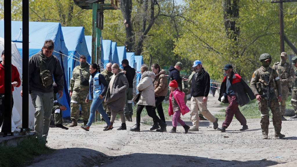 Civilians who left the area near Azovstal steel plant in Mariupol walk at a temporary accommodation centre in Bezimenne