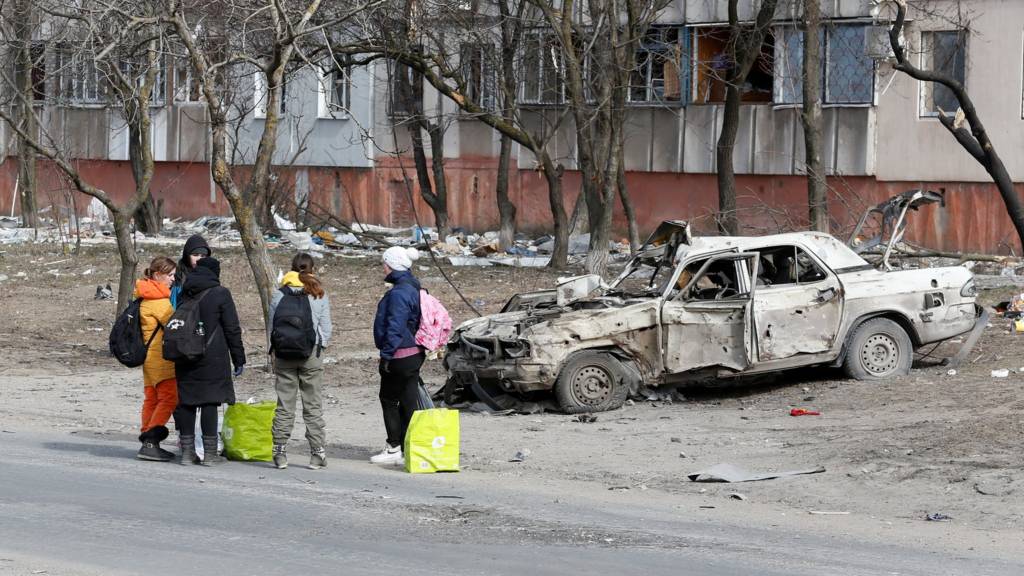 Refugees gather in a street as they leave the city during Ukraine-Russia conflict in the besieged southern port of Mariupol, Ukraine 20 March 2022