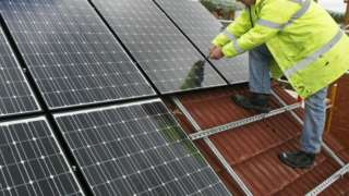Man attaching solar panel to roof