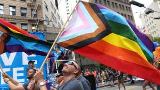 Marchers hold Pride flags as they take part in the 2022 San Francisco Pride Parade.
