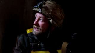 Украинский военнослужащий укрывается от обстрела в Донецкой области