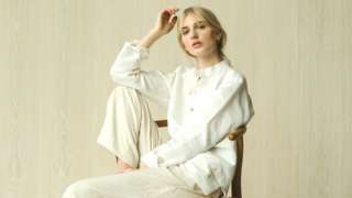 Woman models white button-down shirt