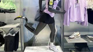 An amputee mannequin in a Nike store with one running shoe and one running blade