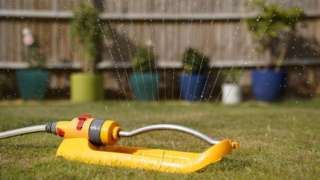 A garden sprinkler is used to water grass