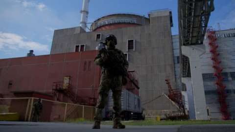 A soldier stands guard outside the plant.