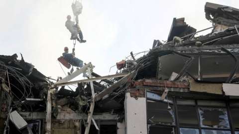 Rescuers at wrecked apartment block in Kyiv, 26 Jun 22