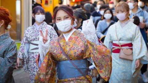 Tourists wearing face masks and traditional outfits in Kyoto