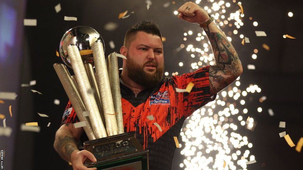 Michael Smith celebrates with PDC World Championship trophy