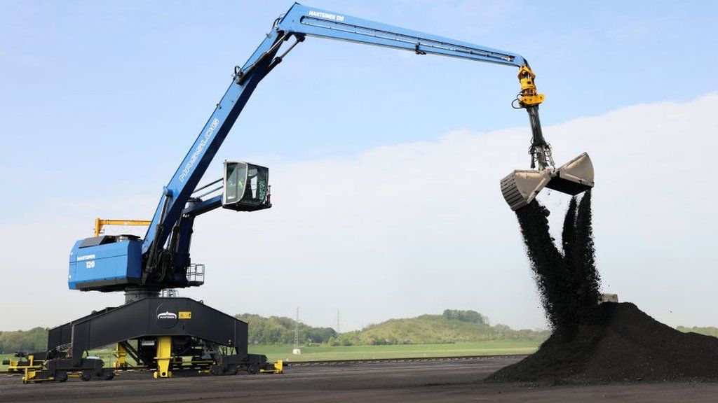 A crane unloads bituminous coal from a barge at Duisburg Port in Duisburg, Germany, 2 May 2022