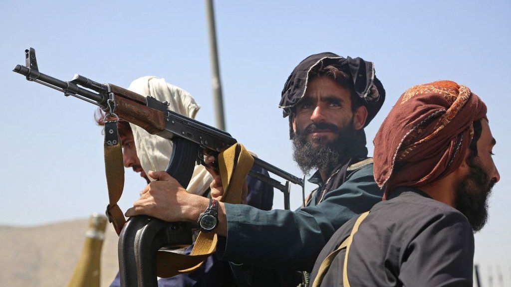 Taliban fighters stand guard in a vehicle along the roadside in Kabul on 16 August.