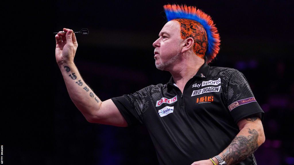 Peter Wright, sporting his trademark a red and blue mohawk, throws a dart