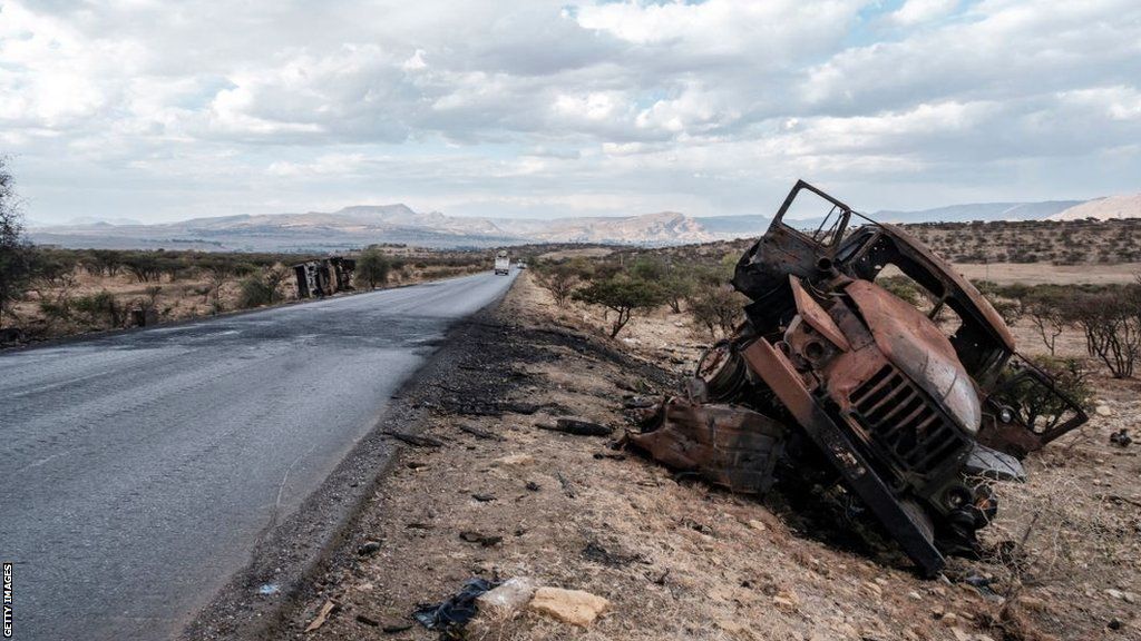 A damaged vehicle stands on a road north of Mekele, the capital of Tigray, on 26 February 2021
