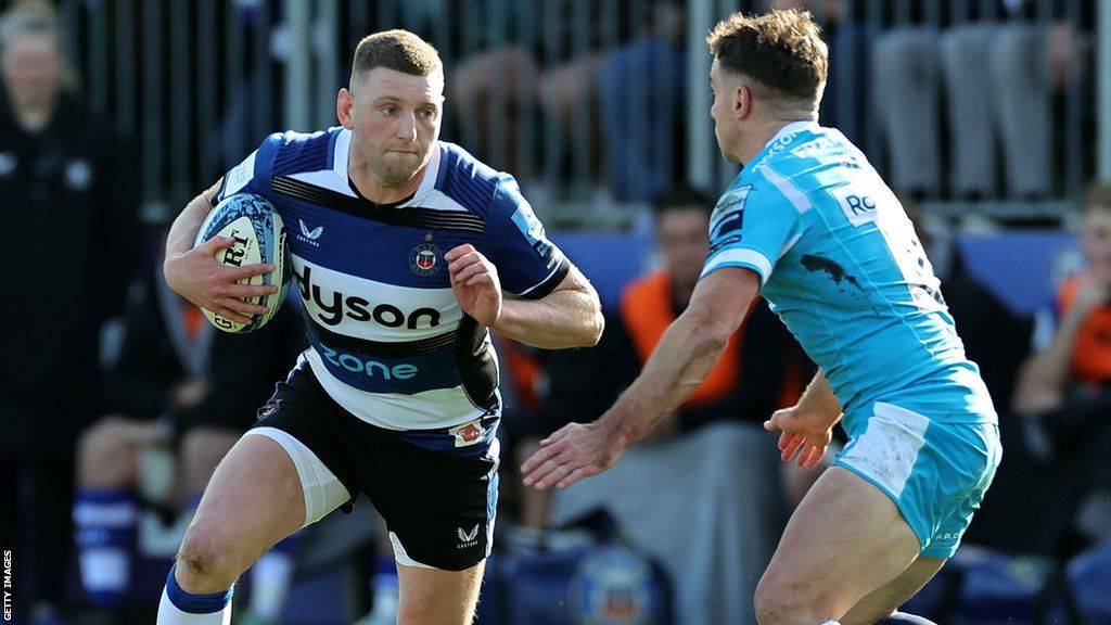 Finn Russell with the ball evades a tackle from George Ford