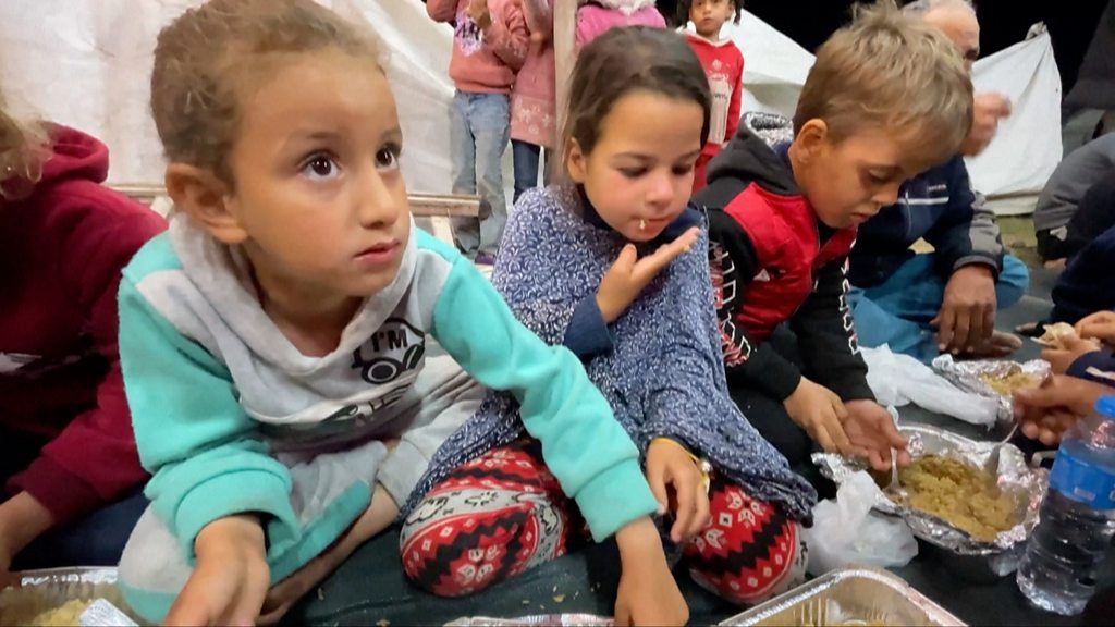 Children share Iftar meal at a camp in Rafah