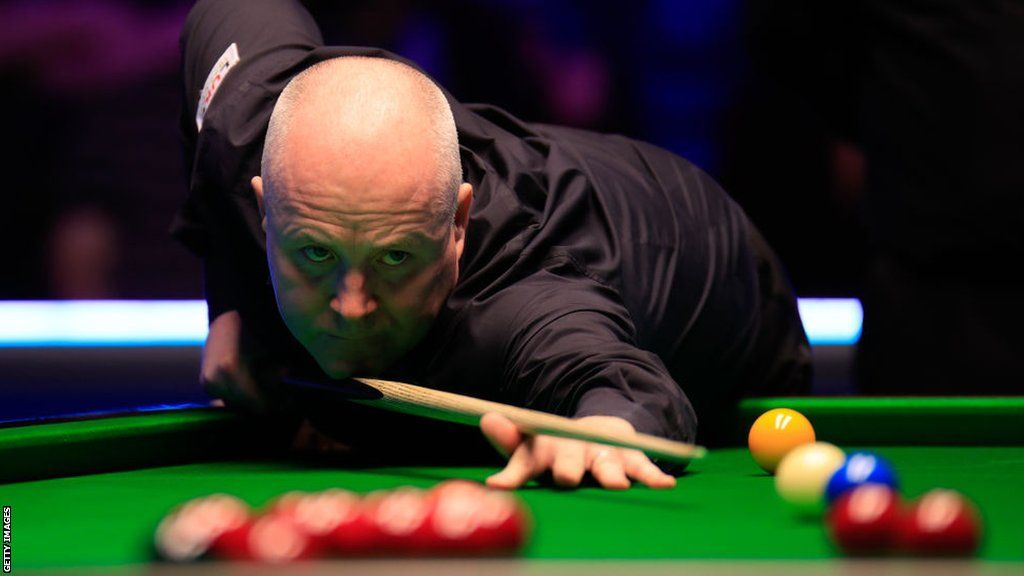 Snooker player John Higgins takes a shot