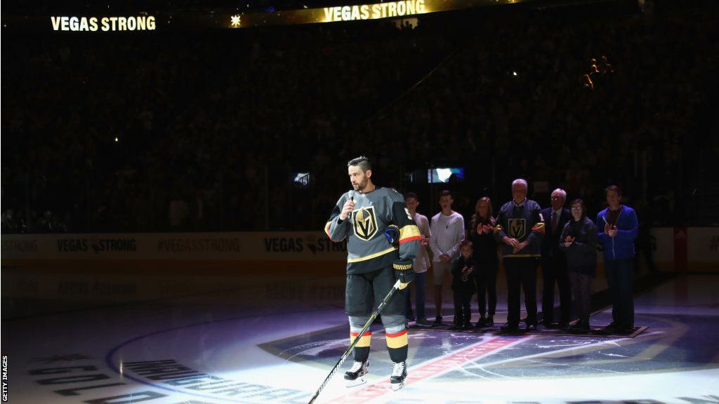 Deryk Engelland speaks to fans under a spotlight while on the ice pre-game for Las Vegas Golden Knights
