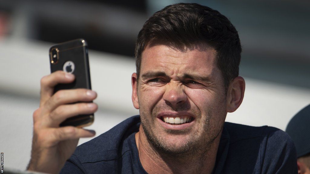 England bowler James Anderson looks at his phone