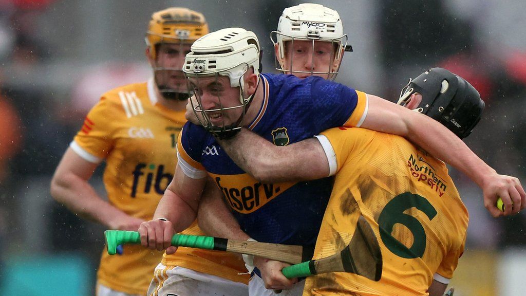 Antrim's Ryan McGarry attempts to halt Tipperary's Eoghan Connolly at Corrigan Park