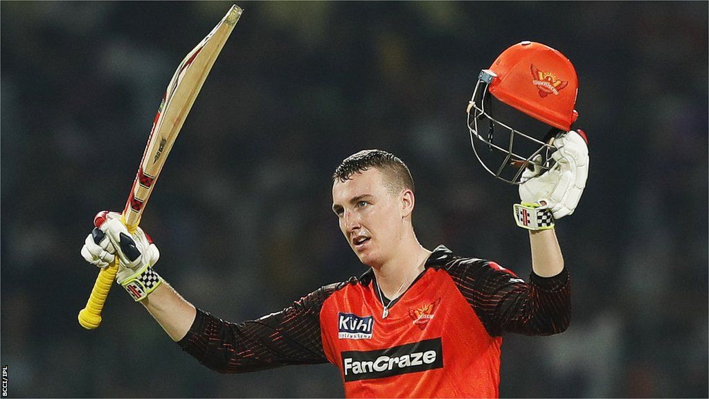 Sunrisers Hyderabad batter Harry Brook raises his bat and helmet in celebration after hitting his first Indian Premier League century