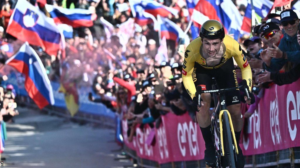 Primoz Roglic rides through a flurry of Slovenian flags on stage 20 of the Giro d'Italia